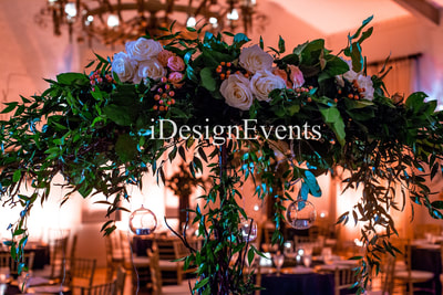 enchanted garden theme wedding reception decor arch with greenery and flowers with chandeliers and huge king loveseat forest by @idesignevents